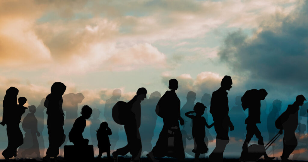 An illustration of a group of refugees walking in silhouette against a cloudy sky